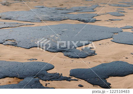 Oil spill in ocean coastline after a tanker wreck. Fuel oil leak and polluted ocean beach, ecological catastrophe 122510483