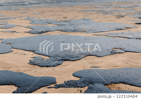 Oil spill in ocean coastline after a tanker wreck. Fuel oil leak and polluted ocean beach, ecological catastrophe 122510484