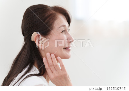 補聴器をつけるシニア女性 補聴器をつけるシニア女性 122510745