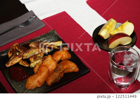 Homemade fish and chip on black plate on red placemat. close up. 122511449