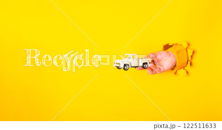Hand holding a toy truck with the word recycle written below it Hand holding a toy truck with the word recycle written below it 122511633