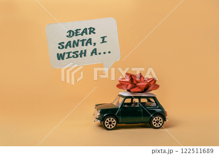 Toy car with a red bow on top of it and a message that says Dear Santa 122511689