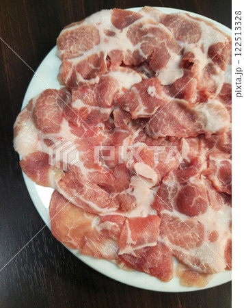Freshly Sliced Pork Meat on White Plate Ready for Cooking Freshly Sliced Pork Meat on White Plate Ready for Cooking 122513328