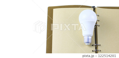 White light bulb on an open notebook, symbolizing creativity, innovation, inspiration and new ideas. White light bulb on an open notebook, symbolizing creativity, innovation, inspiration and new ideas. 122514201
