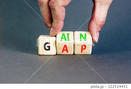 Gain or gap symbol. Concept words Gain Gap on wooden block. Beautiful grey table grey background. Businessman hand. Business gain or gap concept. Copy space. Gain or gap symbol. Concept words Gain Gap on wooden block. Beautiful grey table grey background. Businessman hand. Business gain or gap concept. Copy space. 122514451