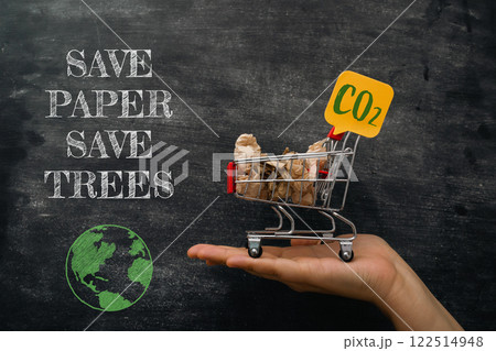 A hand holding a shopping cart with a sign that says Save Paper Save Trees 122514948