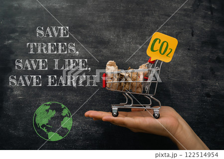 Hand holding a shopping cart with a sign that says Save Trees Hand holding a shopping cart with a sign that says Save Trees 122514954