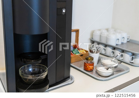 A coffee maker nd clean glasses in the kitchen og a hotel or company. A coffee maker nd clean glasses in the kitchen og a hotel or company. 122515456