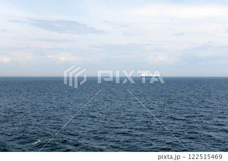 Seascape with a white ferry in the distance and waves. Seascape with a white ferry in the distance and waves. 122515469