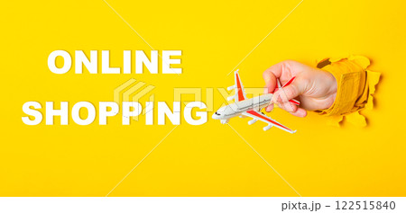 Hand holding a toy airplane with the words Online Shopping written below it Hand holding a toy airplane with the words Online Shopping written below it 122515840