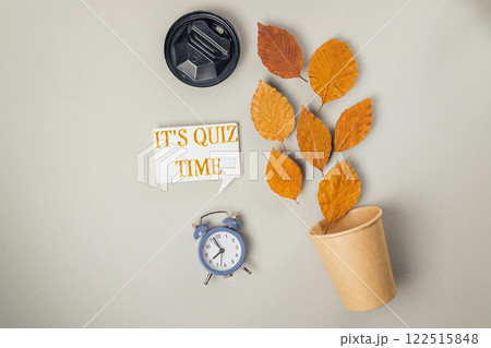 Clock and a cup with leaves on top of it Clock and a cup with leaves on top of it 122515848