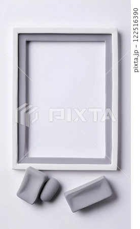 An empty rectangular frame rests against a white gray abstract background. Soft gray clay pieces sit nearby, enhancing the artistic and minimalist aesthetic of the setting. Generative AI 122516390