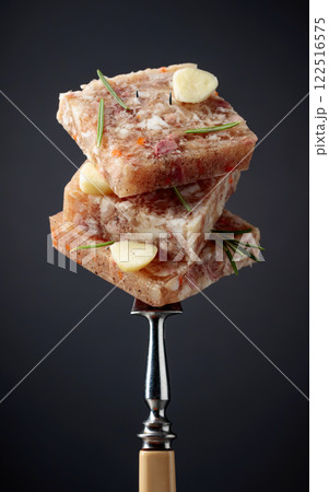 Headcheese on a fork. 122516575