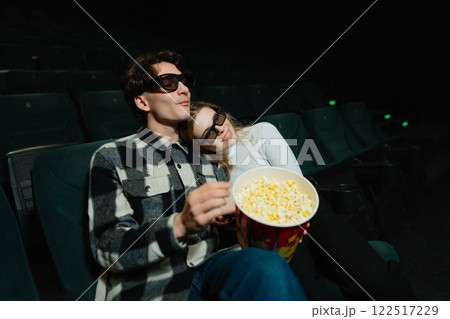 Couple enjoying a movie night together with popcorn in a theater 122517229