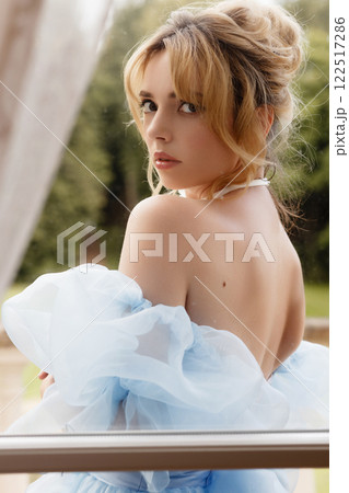 Portrait of an elegant woman in a light blue ball gown in a classic interior 122517286