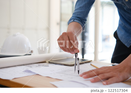 Young architect sketching house plans on a work desk in a modern office 122517304