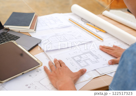 Young architect sketching house plans on a work desk in a modern office 122517323