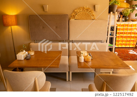 The inviting interior of a coffee shop adorned with warm colors 122517492