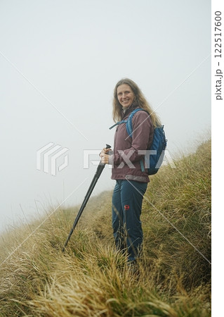 Woman Hiking in Misty Mountains at Foggy Morning 122517600
