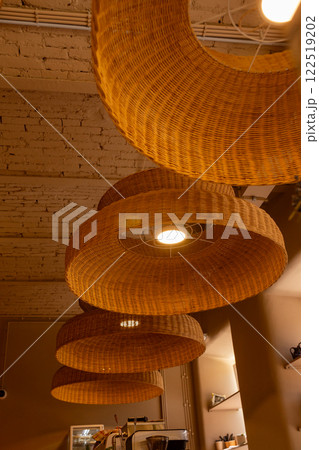 Handmade wicker rattan chandelier hanging at cafeteria in beautiful morning light. Handmade wicker rattan chandelier hanging at cafeteria in beautiful morning light. 122519202