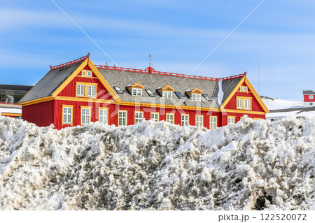 Old red Danish colonial building with snow heap in the foreground, Historical center of Nuuk, Greenland 122520072