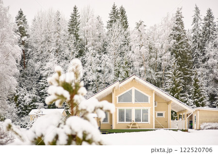 beautiful country house in a snowy pine forest, night lighting, winter fairy tale 122520706