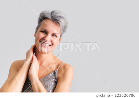 Beautiful happy middle-aged elderly woman with gray short hair smiling and looking at camera. Beautiful happy middle-aged elderly woman with gray short hair smiling and looking at camera. 122520786
