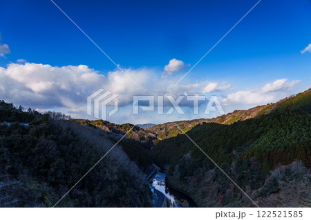 奈良市東部大和高原にある奈良市の水瓶布目ダム　真冬の風景　稜線にだけ光が当たり暗くなっていく布目川① 122521585