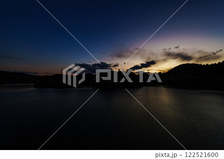 奈良市東部大和高原にある奈良市の水瓶布目ダム　真冬の風景　山際に残る夕焼けとブルーモーメントの空 122521600