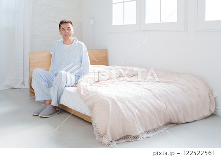 朝ベッドから起床するシニア男性 122522561