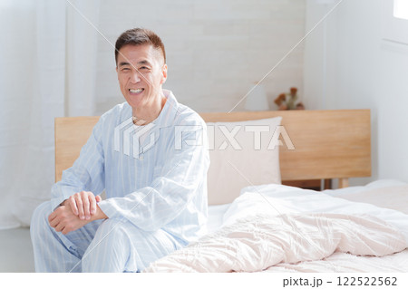 朝ベッドから起床するシニア男性 朝ベッドから起床するシニア男性 122522562