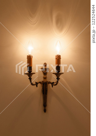A wall mounted light fixture with two candles 122524644
