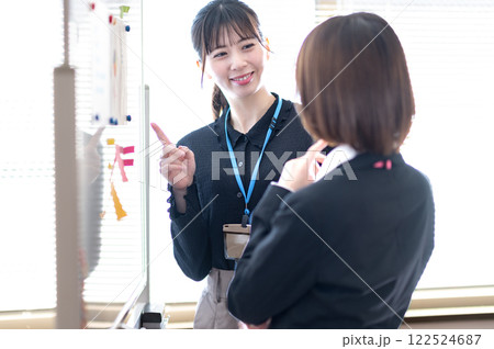 ホワイトボードを使ってデータ分析する若い二人のビジネスウーマン 122524687