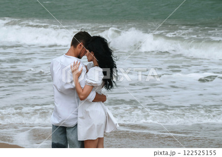 young beautiful couple in love hugging on beach by the sea in summer young beautiful couple in love hugging on beach by the sea in summer 122525155