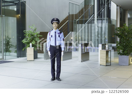 オフィスビルのエントランスロビーに立つ若い警備員　撮影協力:スカパー東京メディアセンター 122526500