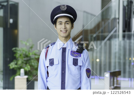 オフィスビルのエントランスロビーに立つ若い警備員　撮影協力:スカパー東京メディアセンター 122526543