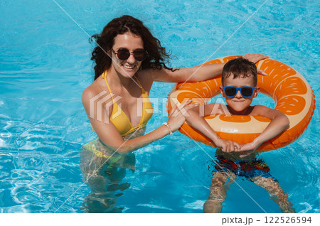 happy young mother and child boy son in swimming pool at a hotel on vacation at a resort in summer 122526594