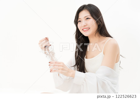 ペットボトルの蓋を開けようとする若い女性 ペットボトルの蓋を開けようとする若い女性 122526623