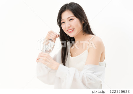 ペットボトルの蓋を開けようとする若い女性 ペットボトルの蓋を開けようとする若い女性 122526628