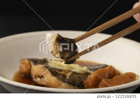 子持ちカレイの煮付けを箸で持ち上げる 122526835