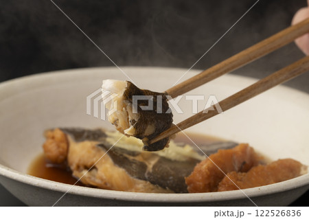 子持ちカレイの煮付けを箸で持ち上げる 122526836