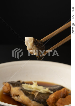 子持ちカレイの煮付けを箸で持ち上げる 122526838