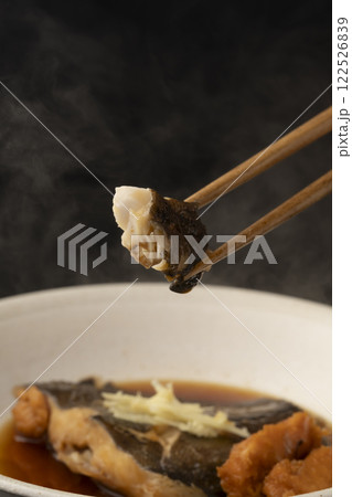 子持ちカレイの煮付けを箸で持ち上げる 122526839