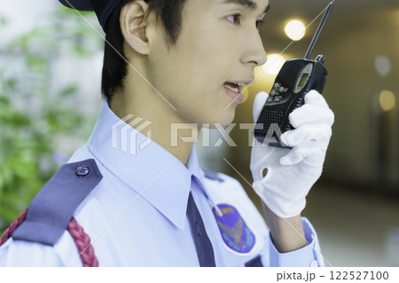 オフィスビルでトランシーバーで会話する若い警備員　撮影協力:スカパー東京メディアセンター 122527100