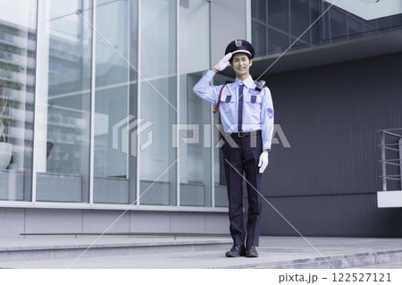 オフィスビルの外に立って敬礼する若い警備員　撮影協力:スカパー東京メディアセンター 122527121