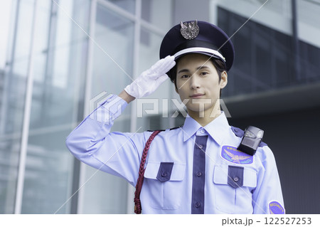 オフィスビルの外に立って敬礼する若い警備員のポートレート　撮影協力:スカパー東京メディアセンター 122527253