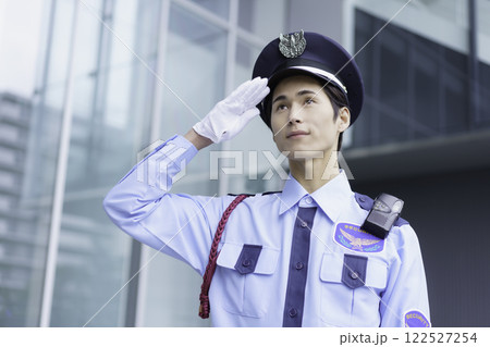 オフィスビルの外に立って敬礼する若い警備員のポートレート　撮影協力:スカパー東京メディアセンター 122527254