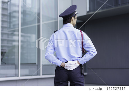 オフィスビルの外に立つ若い警備員の後ろ姿 撮影協力:スカパー東京メディアセンター オフィスビルの外に立つ若い警備員の後ろ姿 撮影協力:スカパー東京メディアセンター 122527315