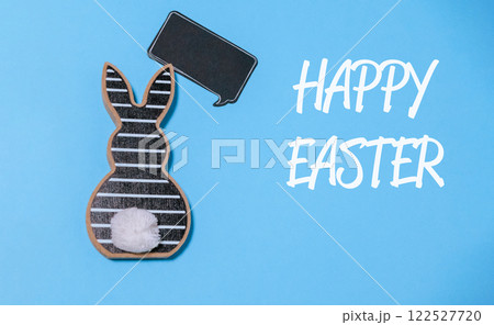 Rabbit is holding a chalkboard with the words Happy Easter written on it 122527720