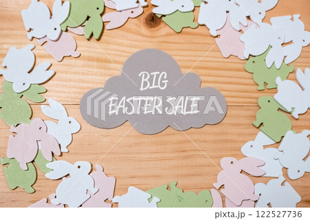 Big Easter sale sign is surrounded by a bunch of Easter bunny decorations 122527736
